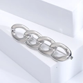 Macro shot of a polished silver chain brooch with interlocking oval rings on white blocks - Silver
