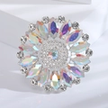 Dettaglio di una spilla rotonda vintage con cristalli colorati AB su fondo in pietra - Argento