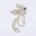 Detalle macro del broche de fénix con diamantes de imitación y perla redonda - Dorado