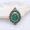 Detalle de broche barroco vintage dorado con filigrana y piedras de turquesa verde - Verde