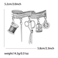 Vintage silver sewing tool brooch featuring scissors and tape measure charms for clothing - Antique Silver