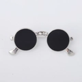 Detailed close-up of a silver sunglasses brooch with black enamel and white rhinestones - Silver