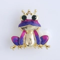 Detailed macro of a gold crown frog brooch with blue-purple gradient enamel and glitters - Purple