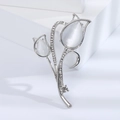 Macro detail of tulip brooch with white opal petals and sparkling inlaid crystals - Silver