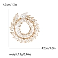 Elegant olive branch wreath brooch in gold metal with rhinestones and product dimensions - Gold