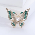 Close-up of golden butterfly brooch with white rhinestones and green marquise gems - Green