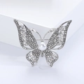 Detailed macro view of butterfly brooch with white pearl and sparkling crystals - Silver