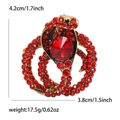 Golden cobra snake brooch featuring sparkling red rhinestones and centered faceted stones - Antique Gold Red