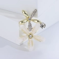 Elegant floral brooch featuring sparkling crystals and white petals on a polished metal base - White