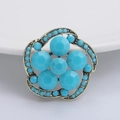 Macro detail of vintage floral brooch featuring sky blue beads and antique gold filigree - Turquoise Blue