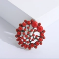Spilla circolare vintage in bronzo con perline rosse su un piedistallo bianco pulito - Rosso