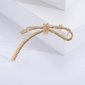 Elegante spilla a fiocco vintage dorata con trama a corda su supporto bianco - Oro