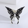 Detaillierte Nahaufnahme einer Vintage-Schmetterlingsbrosche mit schwarzer Emaille und Strass - Gold