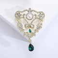 Macro detail of vintage baroque brooch with gold base, white pearls and green drop pendants - Green