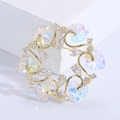 Macro shot of gold floral wreath brooch with heart crystals and sparkling cubic zirconia - AB White
