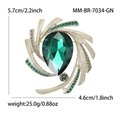 Vintage gold brooch with large pear-shaped green crystal and sparkling swirl design - Green