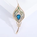 Elegante spilla a piuma di pavone dorata con cristallo blu e smalto verde su base bianca - Blu