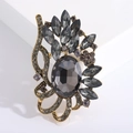 Vue détaillée de broche vintage en or avec cristaux gris et motifs floraux baroques - Gris