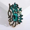 Detail of vintage gold brooch with dark green oval stone and marquise crystals - Green