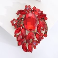 Dettaglio macro della spilla floreale vintage con cristalli rossi e base dorata - Rosso