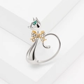 Cute silver cat ring with green crystal eyes and a golden diamond bow on white background - Silver Cat With Gold Bow