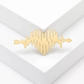 Minimalist golden heart arrow brooch with heartbeat line pulse design on a white platform - Gold