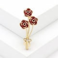 Detail der roten Emaille Rosenbrosche mit goldenem Stiel und funkelnder Strass-Schleife - Rot