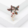 Vintage gold butterfly brooch with colorful rhinestones on a white geometric background - Colorful Butterfly (MM-BR-MX)