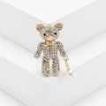 Broche de oso con pedrería brillante y colgante de perla blanca sobre soporte blanco - Dorado