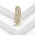 Elegante broche de pluma dorada con diamantes de imitación en soporte geométrico blanco - Dorado