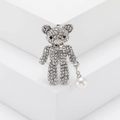 Primer plano detallado de un broche de oso plateado con diamantes de imitación y perla - Plateado