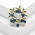 Elegant gold berry wreath brooch with green enamel leaves and ten glossy blue beads - Blue