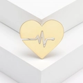 Broche cœur dorée polie avec motif ECG sur un support de présentation blanc géométrique - Doré