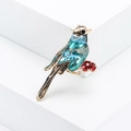 Exquisite blue enamel bird brooch with a red flower on a geometric display - Blue