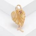 Elegante broche de hoja en concha amarilla con detalles dorados y una pequeña mariquita - Amarillo