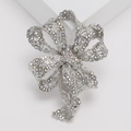 Detail van elegante zilveren strikbroche met AB-strass op een witte achtergrond - Zilver (MM-BR-3669-SL)
