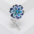 Vista detallada de un elegante broche de flor en cristal azul con baño de plata - Azul