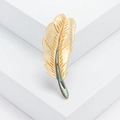 Elegant feather brooch crafted with natural mother of pearl on a white pedestal - Yellow