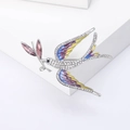 Enamel swallow bird brooch with colorful wings and crystals on a white pedestal - Purple