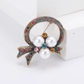 Broche vintage dorée avec strass colorés et trois perles sur fond blanc épuré - Or Ancien Strass Multicolore
