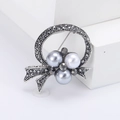 Détail d'une broche vintage avec perles grises et nœud en strass anthracite - Argent Ancien Strass Noir