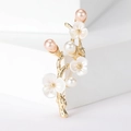 Macro detail of elegant golden peach blossom branch brooch with pearls and white enamel flowers - Gold