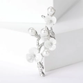 Detailed view of floral peach blossom brooch with pearls and white enamel finish - Silver