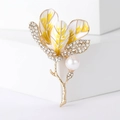 Detailaufnahme einer Hibiskus-Brosche mit Goldmetall, Emaille-Blüten und weißer Perle - Gelb