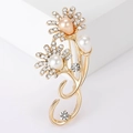 Elegante broche de flor dorada con pedrería brillante y perlas sobre un soporte blanco - 3724-Dorado