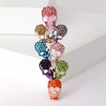 Broche de calavera colorida con pedrería brillante estilo punk en fondo blanco - Colorido