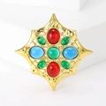 Vintage goldene Sternbrosche mit bunten Cabochon-Steinen auf weißem Hintergrund - Bunt Gestreift