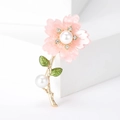 Close-up of pink daisy brooch with central pearl and sparkling rhinestone accents - Pink