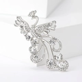 Macro shot of silver phoenix brooch with detailed rhinestone pavé wings and long tail - Silver