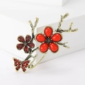 Elegant butterfly and red plum flower brooch in antique gold with vibrant ruby stones - Red